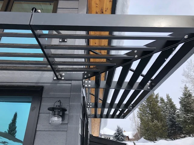 Underside of an aluminum trellis canopy over a building entrance